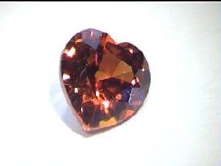 Zircon ovale aux tons cognac-rouge d’Afrique